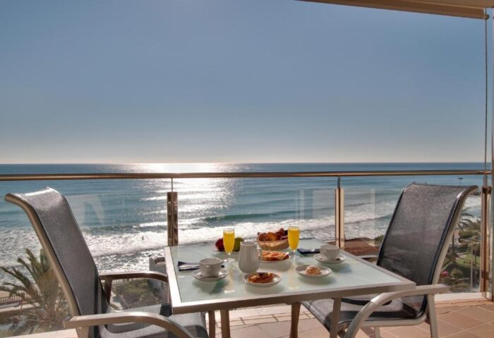 Breakfast with a view at Hotel Calipolis, a gay-friendly hotel. Ocean view from balcony with table set for two. Perfect for gay travel.