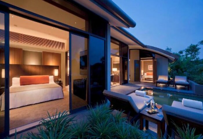 Capella Singapore Hotel's gay-friendly suite. Poolside loungers, cocktails, and a luxurious bedroom await gay travelers. A perfect gay vacation!
