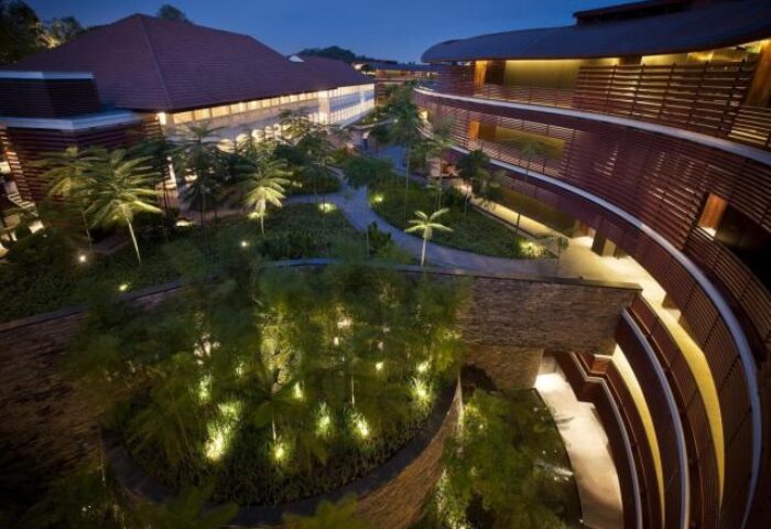 Night view of Capella Singapore Hotel, a gay-friendly hotel. Lush greenery and modern architecture blend seamlessly in this luxury resort.