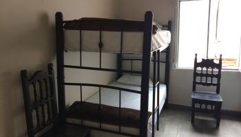Capsule Hostel room: Bunk bed, chairs, window. Budget-friendly gay-friendly hotel option for the solo gay traveler.