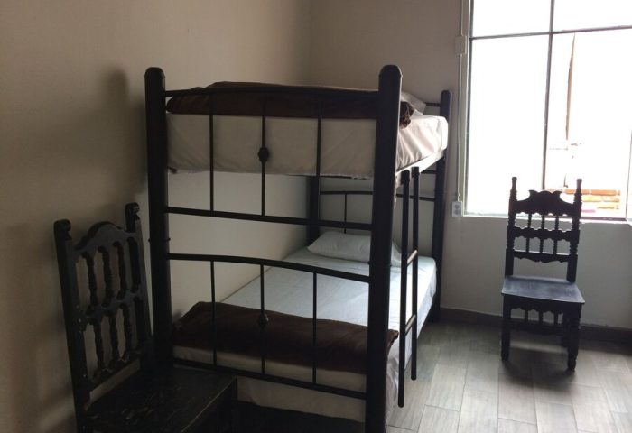 Capsule Hostel room: Bunk bed, chairs, window. Budget-friendly gay-friendly hotel option for the solo gay traveler.