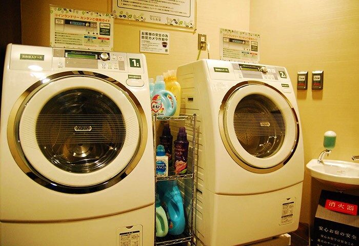 Laundry facilities at Anshin Oyado Premier Tokyo Shinjuku Station, a gay-friendly capsule hotel. Washers, detergent, & sink for gay travelers.
