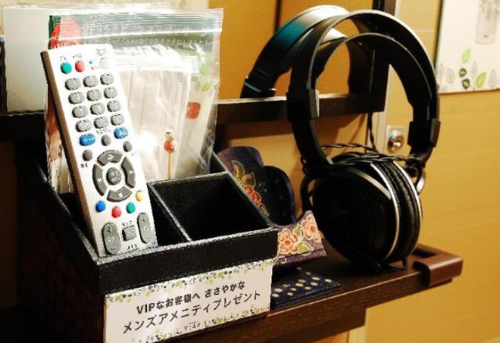 Amenities at Anshin Oyado Premier, a gay-friendly capsule hotel near Shinjuku Station, Tokyo. Includes remote, headphones, & men's amenity kit.