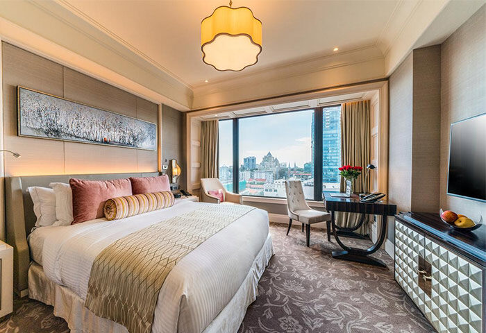 Gay-Friendly Caravelle Saigon Hotel room. Luxurious bed, city view. Upscale travel for gay men. Saigon hotel room interior.