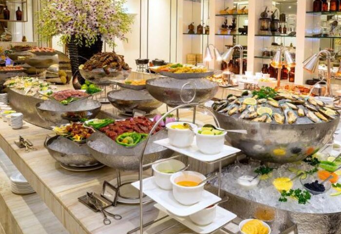 Buffet at Gay-Friendly Caravelle Saigon Hotel. Large bowls of seafood, meats, and sauces. A luxurious dining experience for gay travelers.