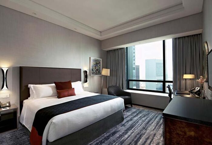 Carlton City Hotel Singapore room. Gay-friendly hotel with bed, desk, and city view. Modern design. Comfortable stay.