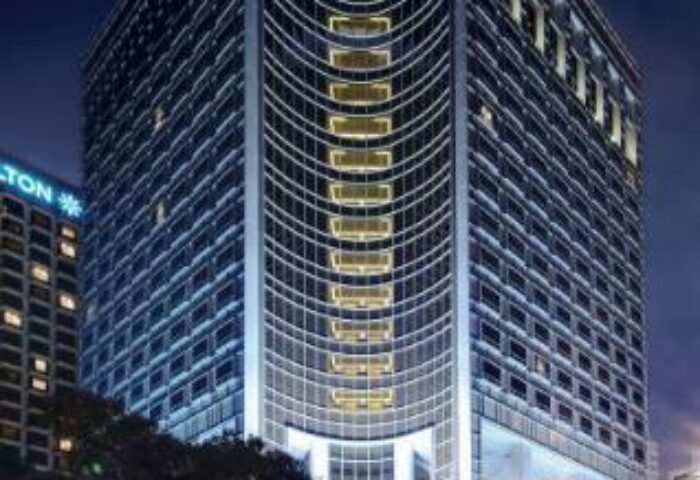 Carlton Hotel Singapore, a gay-friendly hotel. Night view of the hotel's exterior, showcasing its modern architecture and illuminated signage.