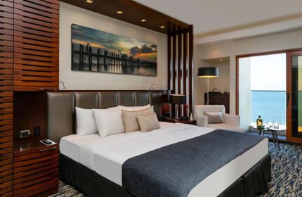 Carlton Tel Aviv Hotel luxury room. Gay-friendly hotel on the beach with ocean view. Upscale decor, king bed, and balcony.