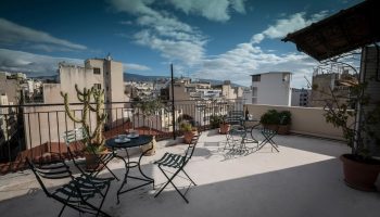 Rooftop view at the Carolina Hotel, a gay-friendly hotel. Table and chairs offer a relaxing space with city views. #gaytravel #hotel