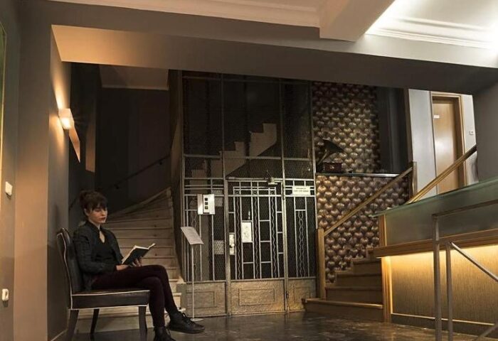 Carolina Hotel: Woman reading in the lobby of this gay-friendly hotel. Staircases, metal gate, and unique decor create a stylish, welcoming atmosphere.