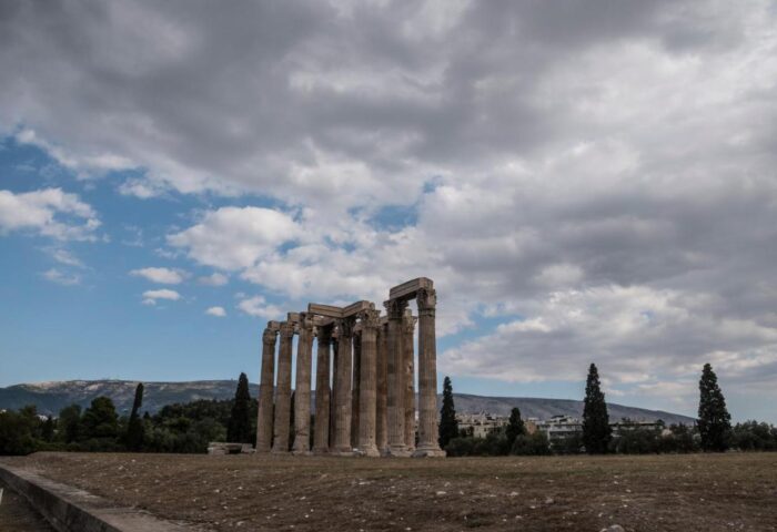 Temple of Olympian Zeus ruins in Athens. Ancient Greek landmark with towering columns and cloudy sky. Gay travel destination.