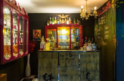 Casa Comtesse's bar area. This gay-friendly hotel features a stylish bar with a black and white checkered floor, and unique decor.