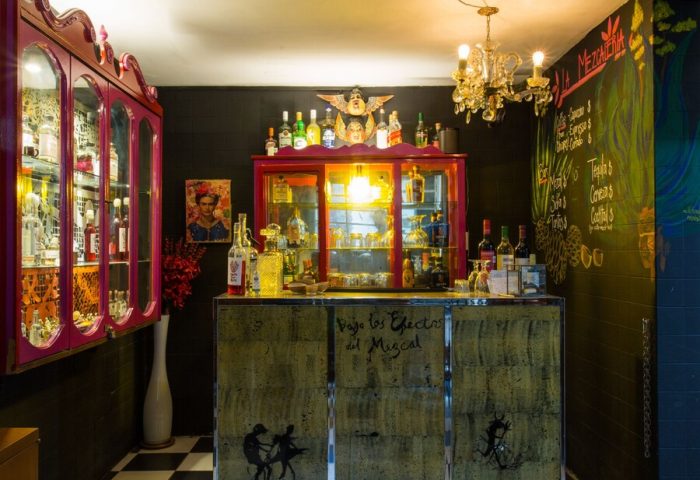 Casa Comtesse's bar area. This gay-friendly hotel features a stylish bar with a black and white checkered floor, and unique decor.