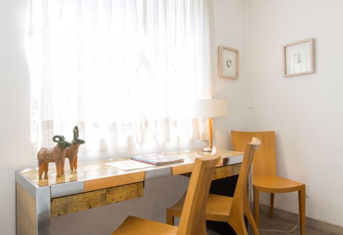 Casa Comtesse gay-friendly hotel room: Desk area with wooden chairs, lamp, and sheer curtains. A comfortable workspace for gay travelers.