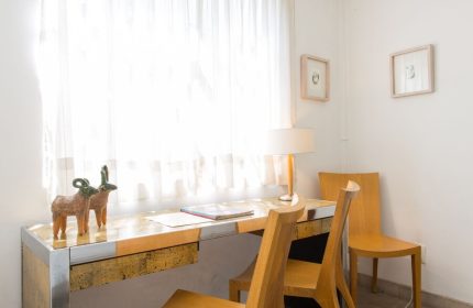 Casa Comtesse gay-friendly hotel room: Desk area with wooden chairs, lamp, and sheer curtains. A comfortable workspace for gay travelers.