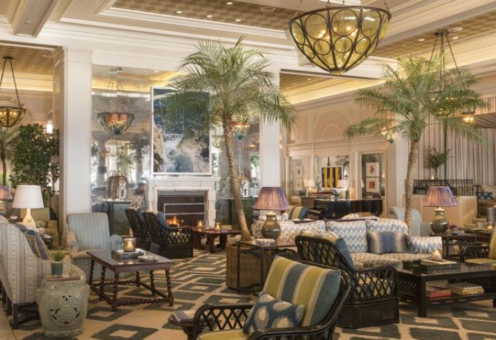 Casa Del Mar gay-friendly hotel lobby. Elegant seating area with palm trees, fireplace, and stylish decor. Ideal for gay men's travel.