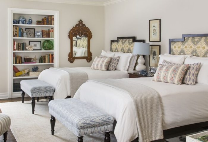 Casa Del Mar gay-friendly hotel room with two beds, patterned headboards, benches, and a bookshelf. Ideal for gay travel and vacation.