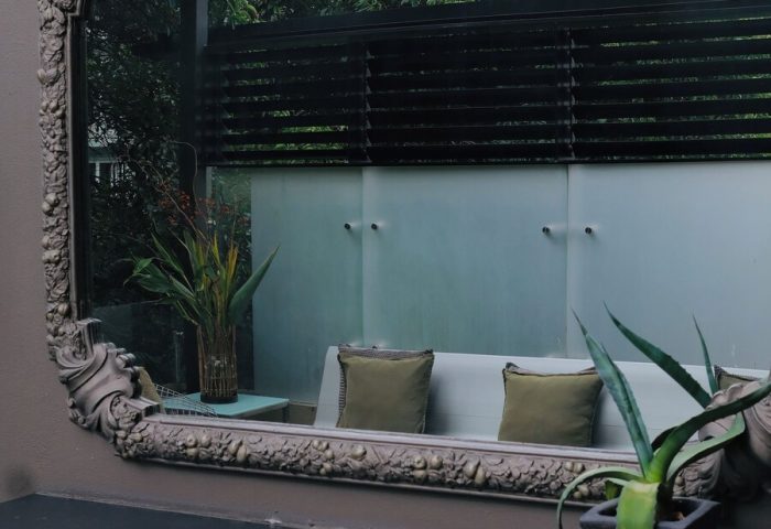 Casa Mannach gay-friendly hotel: Ornate mirror reflecting a stylish outdoor lounge area, showcasing the hotel's design and ambiance.