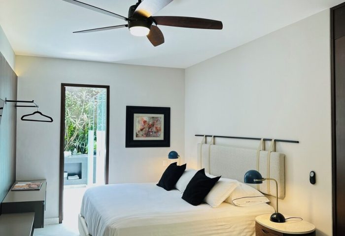Casa Mannach, a gay-friendly hotel. Bedroom interior with a king bed, ceiling fan, and modern decor. Ideal for gay travel.