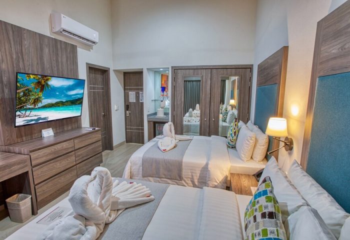 Casa Nicole Boutique Hotel room. Gay-friendly hotel with two beds, swan towels, TV, closet, and modern decor. Ideal for gay travel.