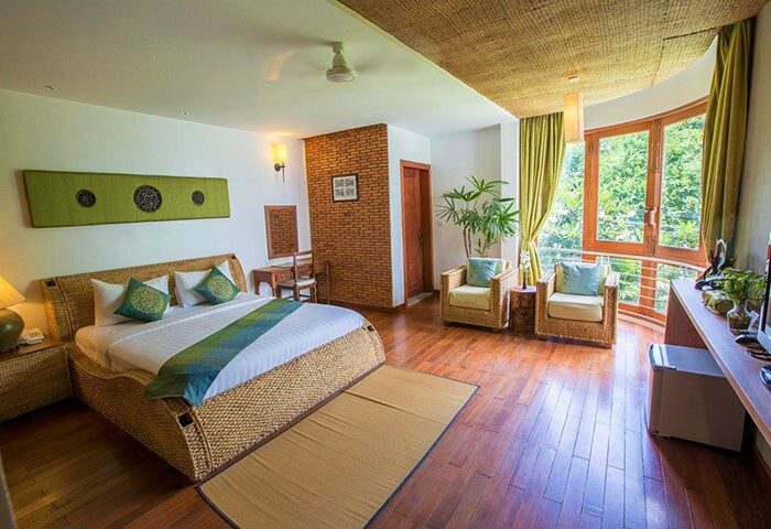 Casa Villa Independence room. Gay-friendly hotel with rattan bed, seating area, and large windows. Relaxing stay for gay travelers.