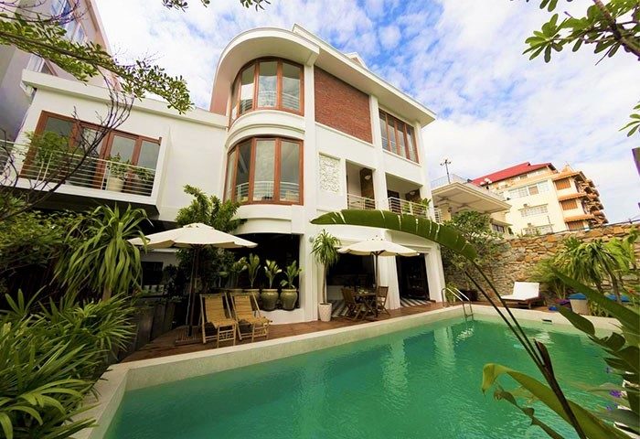 Casa Villa Independence, a gay-friendly hotel. Poolside view of the villa, with a modern design, lush greenery, and inviting pool.