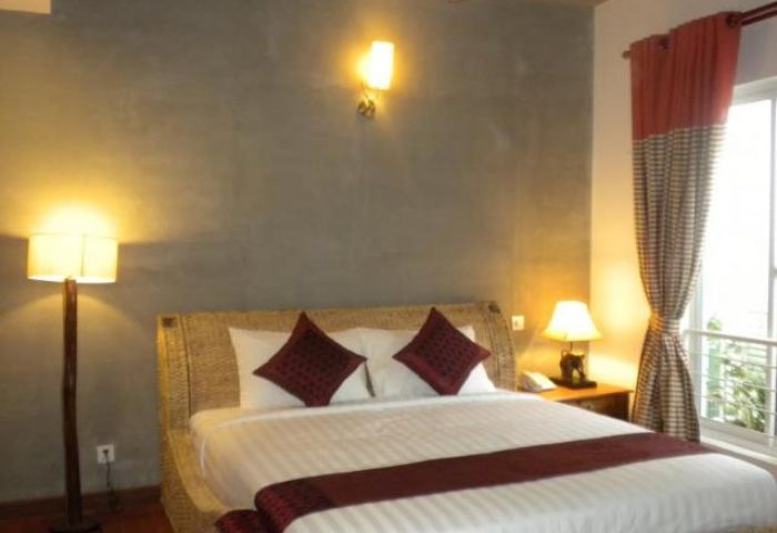 Casa Villa Independence gay-friendly hotel room. A cozy bedroom with a queen bed, lamps, and curtains. Gay travel accommodation.