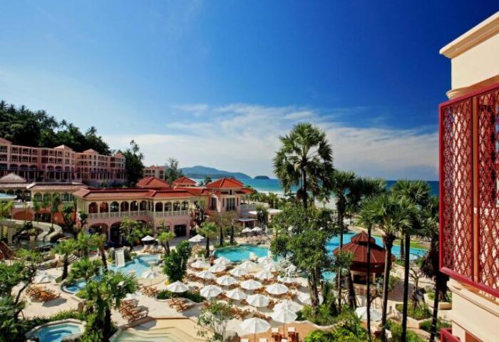 Centara Grand Beach Resort Phuket view. Gay-friendly hotel with pools, palm trees, umbrellas, and beach access. Ideal for gay travel.