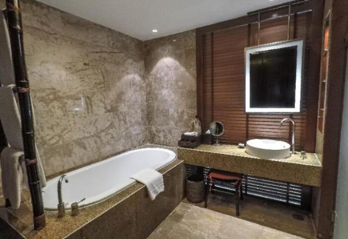 Bathroom at Centara Grand Beach Resort & Villas Krabi, a gay-friendly hotel. Features a bathtub, sink, mirror, and luxurious design.
