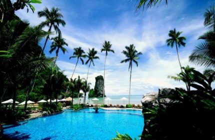 Centara Grand Beach Resort & Villas Krabi pool view. A gay-friendly hotel with palm trees and ocean views.