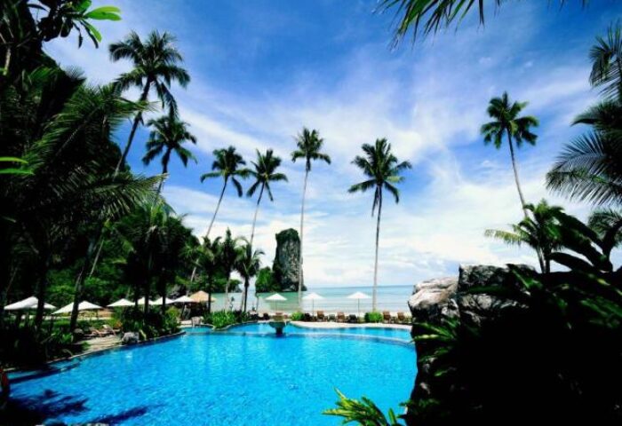 Centara Grand Beach Resort & Villas Krabi pool view. A gay-friendly hotel with palm trees and ocean views.