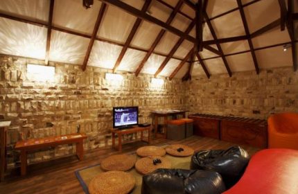 Centara Grand Island Resort & Spa, Maldives: Interior view with bean bags, stone walls, and wooden beams. Gay-friendly hotel travel.