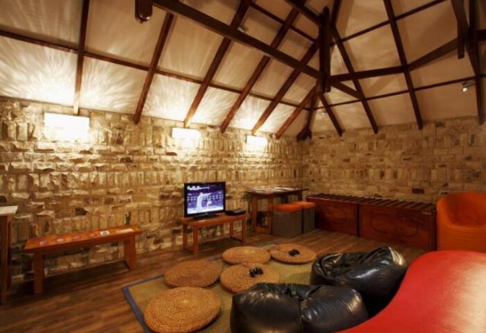 Centara Grand Island Resort & Spa, Maldives: Interior view with bean bags, stone walls, and wooden beams. Gay-friendly hotel travel.