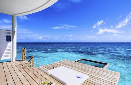 Centara Grand Island Resort & Spa Maldives gay-friendly hotel. Overwater bungalow deck with ocean view, lounge chair, & swim platform.