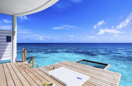 Centara Grand Island Resort & Spa Maldives gay-friendly hotel. Overwater bungalow deck with ocean view, lounge chair, & swim platform.