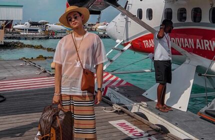 Gay traveler at Centara Grand Island Resort & Spa Maldives. Stylish man with seaplane. Gay-friendly hotel. Luxury travel. Maldives vacation.