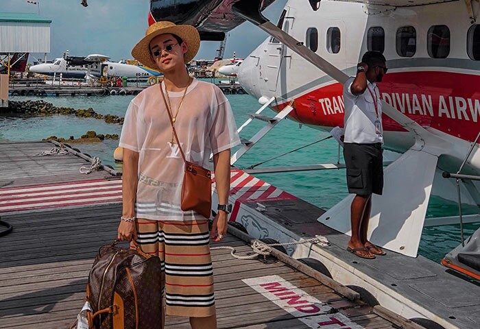 Gay traveler at Centara Grand Island Resort & Spa Maldives. Stylish man with seaplane. Gay-friendly hotel. Luxury travel. Maldives vacation.