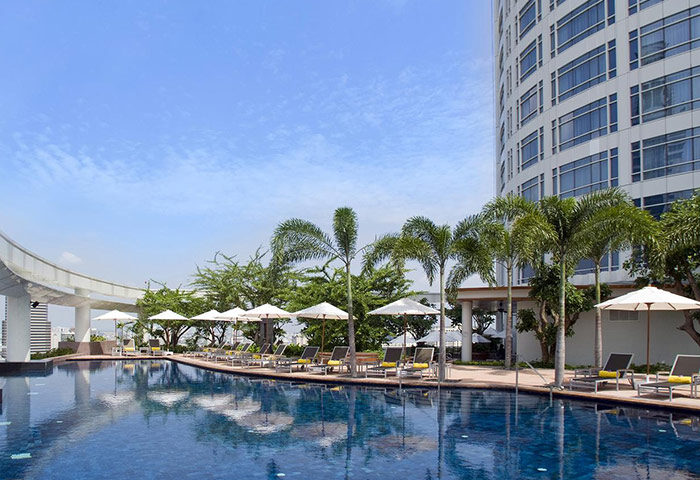 Pool at Gay-Friendly Centara Grand at Central World Hotel, SHA Certified. Bangkok hotel with lounge chairs and umbrellas.