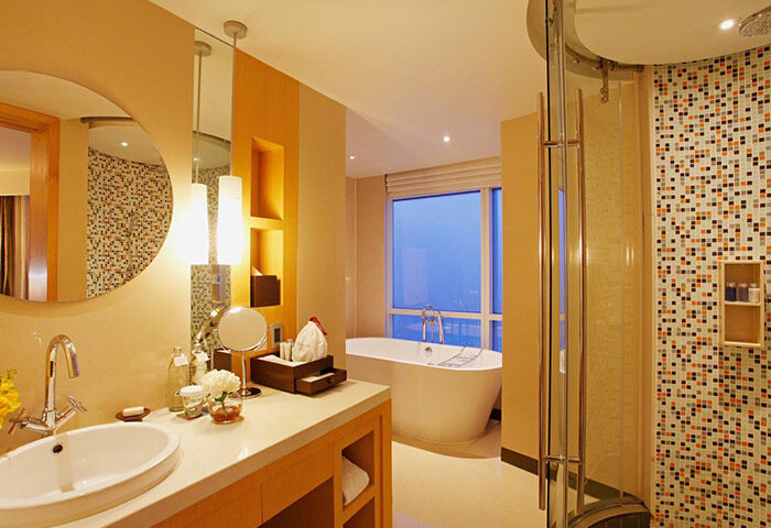 Centara Grand at Central World Hotel bathroom. Modern design with tub, shower, sink, and mosaic tiles. Gay-friendly hotel in Bangkok.