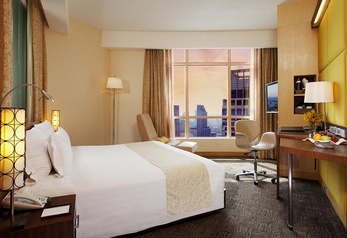 Centara Grand at Central World Hotel room. Gay-friendly hotel in Bangkok with city view. SHA Certified hotel room with bed and desk.