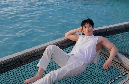 Gay man relaxing on a net over water at Centara Ras Fushi Resort & Spa, Maldives. Gay-friendly hotel for LGBTQ travelers.