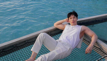Gay man relaxing on a net over water at Centara Ras Fushi Resort & Spa, Maldives. Gay-friendly hotel for LGBTQ travelers.