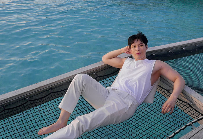 Gay man relaxing on a net over water at Centara Ras Fushi Resort & Spa, Maldives. Gay-friendly hotel for LGBTQ travelers.