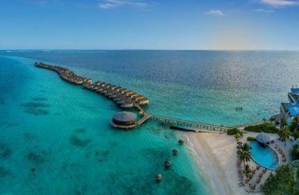 Centara Ras Fushi Resort & Spa Maldives aerial view. Gay-friendly hotel with overwater bungalows, pool, beach, and turquoise water.