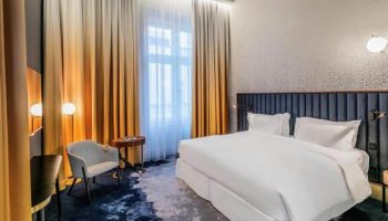 Hotel Century Old Town Prague MGallery room. Gay-friendly, pet-friendly hotel with modern decor. Comfortable bed, chair, and stylish design.