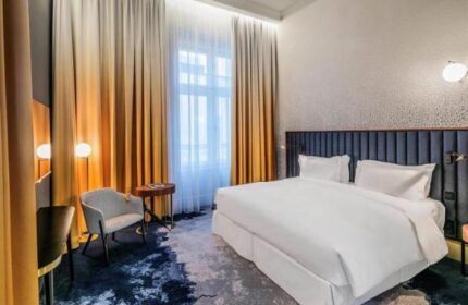 Hotel Century Old Town Prague MGallery room. Gay-friendly, pet-friendly hotel with modern decor. Comfortable bed, chair, and stylish design.