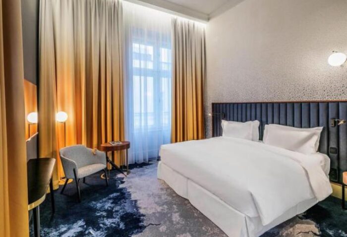 Hotel Century Old Town Prague MGallery room. Gay-friendly, pet-friendly hotel with modern decor. Comfortable bed, chair, and stylish design.