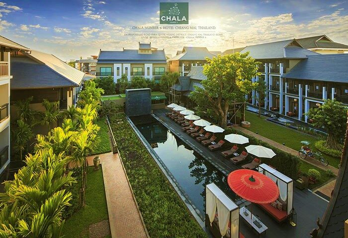 Chala Number 6, a gay-friendly hotel in Chiang Mai, Thailand. Aerial view of the pool, lounge chairs, and lush greenery. Perfect for gay travel.