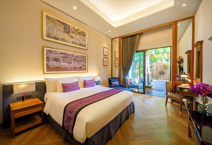 Chala Number 6 gay-friendly hotel room. King bed with purple accents, desk, and patio with outdoor tub. Upscale gay travel lodging.