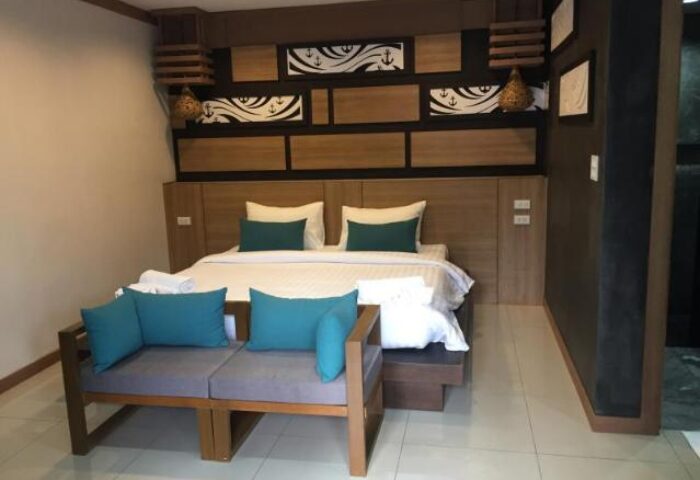 ChaoKoh Phi Phi Hotel & Resort room. Gay-friendly hotel bedroom with king bed, couch, and nautical decor. Ideal gay travel in Thailand.